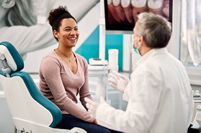 smiling dental patient and dentist talking