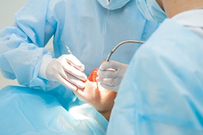 dentist and assistant performing oral surgery on a patient