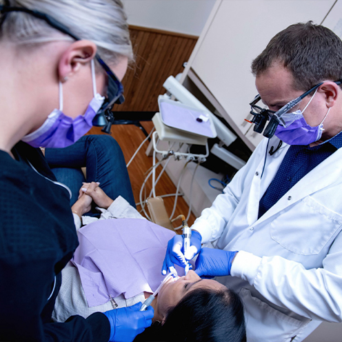 Doctor Young and dental assistant treating a dental patient