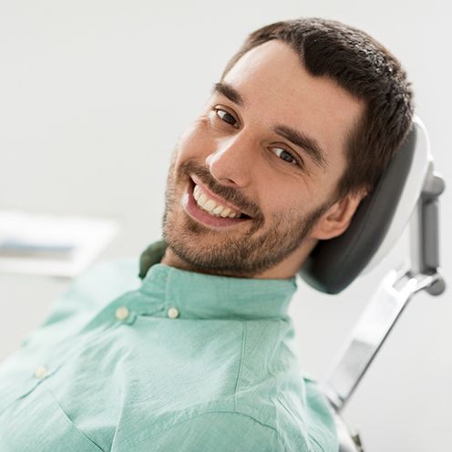 A smiling man sitting in a dentist’s chair