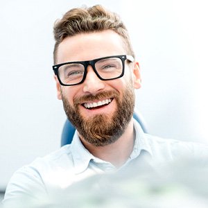 man smiling while sitting in treatment chair