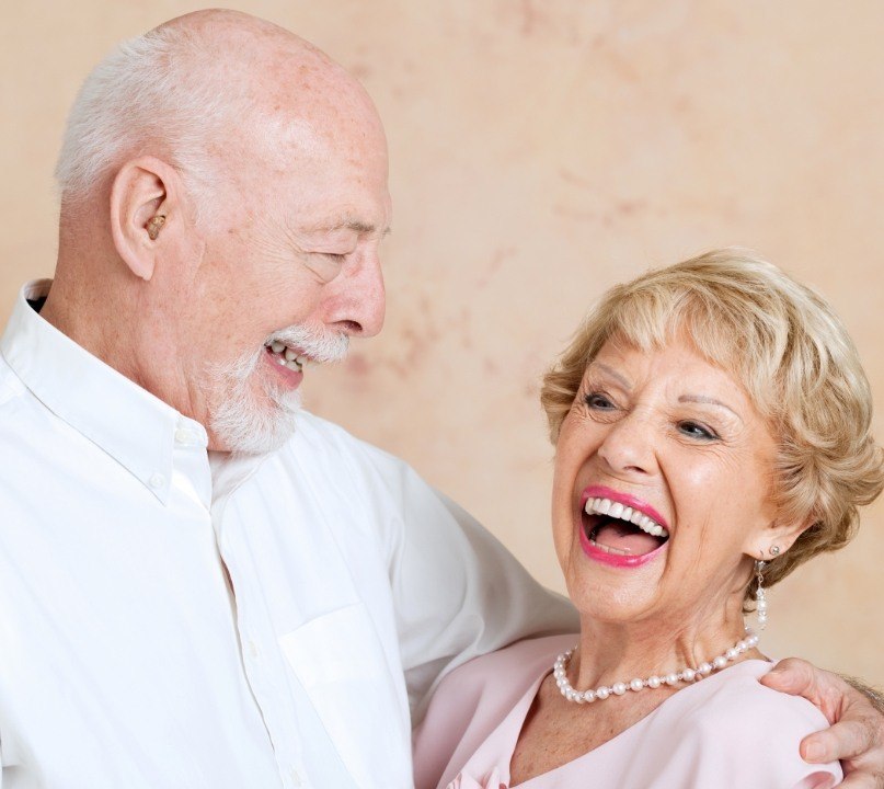 Senior man and woman laughing with dental implants in Palos Heights