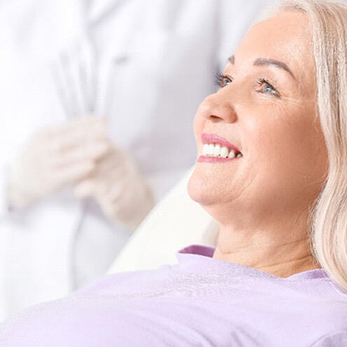 patient smiling while sitting in treatment chair