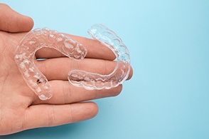  dentist holding clear aligners