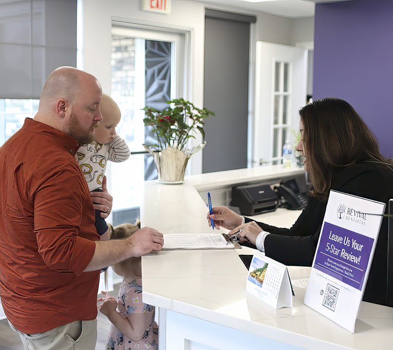 Palos Heights dental team member showing a clipboard to a patient