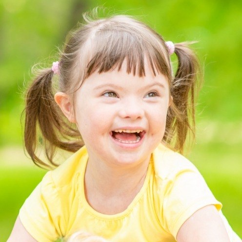 Young girl with special needs smiling outdoors