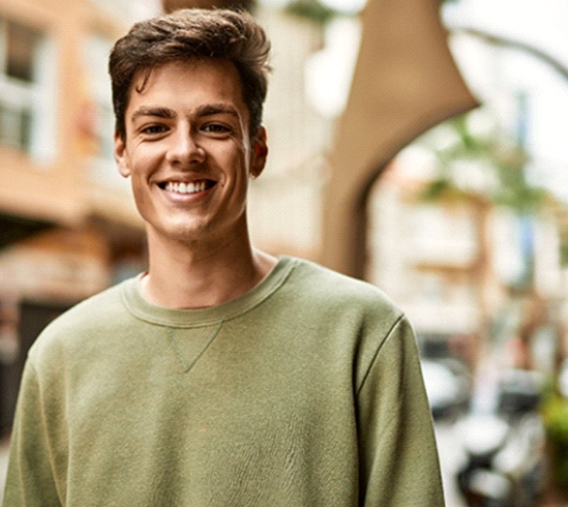 man smiling while standing outside