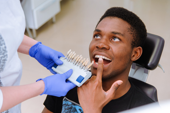 man smiling while visiting cosmetic dentist